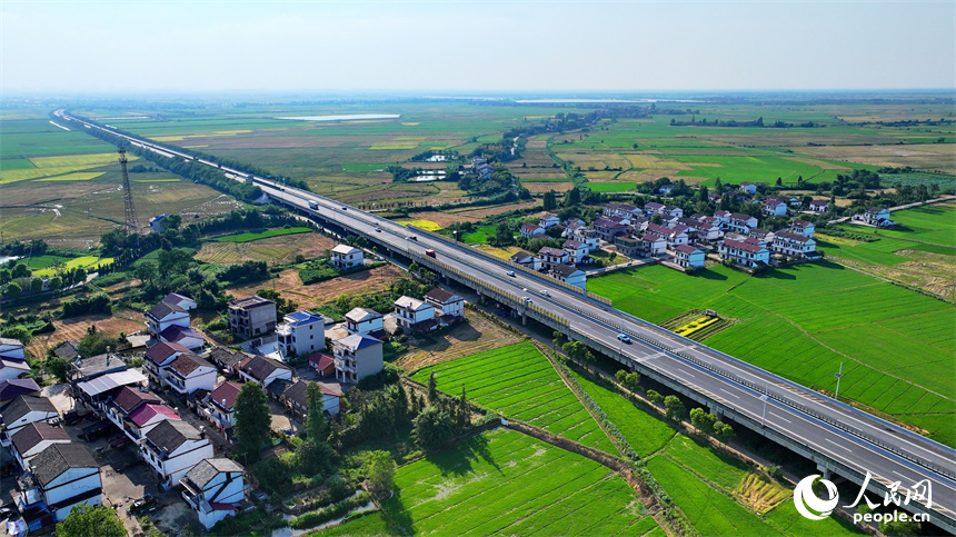 南昌市南昌縣涇口鄉，杭長高速公路上的車輛穿村而過，沿途田園廣袤、碧波萬頃，美景如畫。人民網 朱海鵬攝