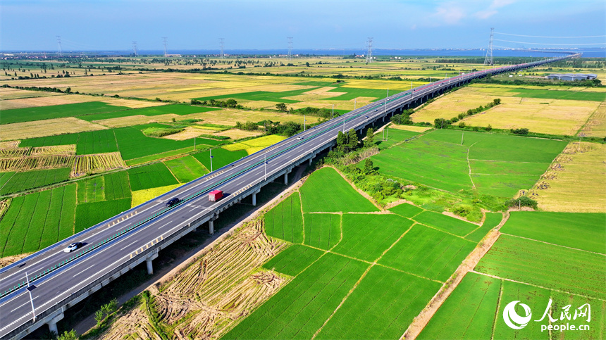 南昌市南昌县泾口乡，杭长高速公路上的车辆穿村而过，沿途田园广袤、碧波万顷，美景如画。人民网 朱海鹏摄