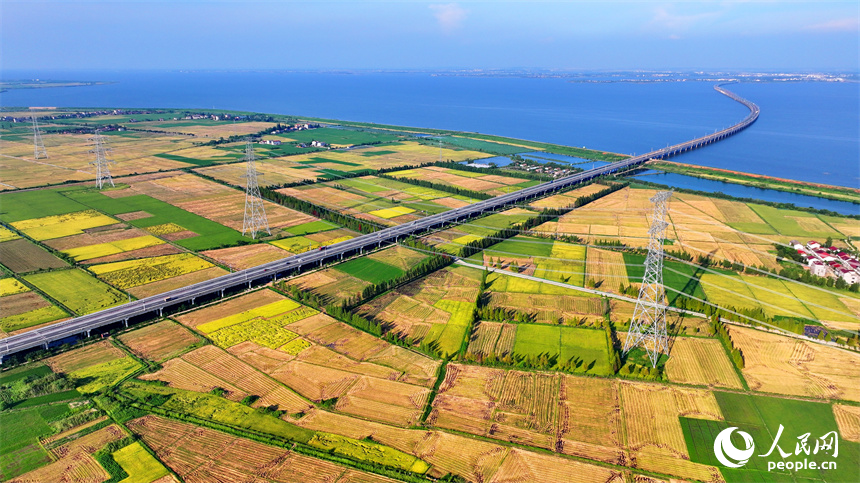 南昌市南昌縣涇口鄉，杭長高速公路上的車輛穿村而過，沿途田園廣袤、碧波萬頃，美景如畫。人民網 朱海鵬攝