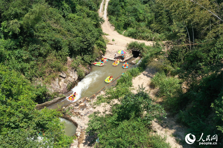 上高縣峽谷漂流水道上色彩斑斕，游客們在漂流艇上戲水消暑。人民網記者 時雨攝