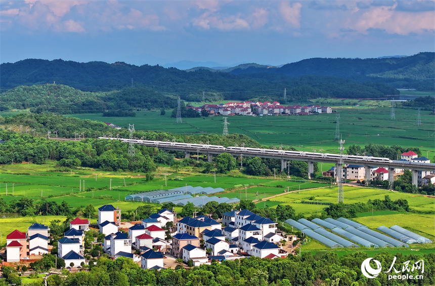 在建的東臨環城高速公路與農房、青山、綠樹、田壟相映成景，鄉村和美如畫。人民網 朱海鵬攝