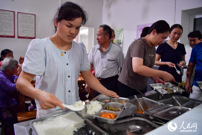 胡家村居家养老服务中心内，工作人员正在为老人们打饭。人民网记者 时雨摄