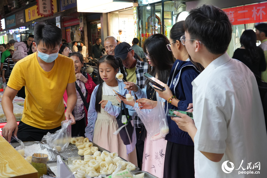 10月3日，南昌市东湖区大士院街区，游客购买品尝当地特色小吃白糖糕。人民网记者 毛思远摄