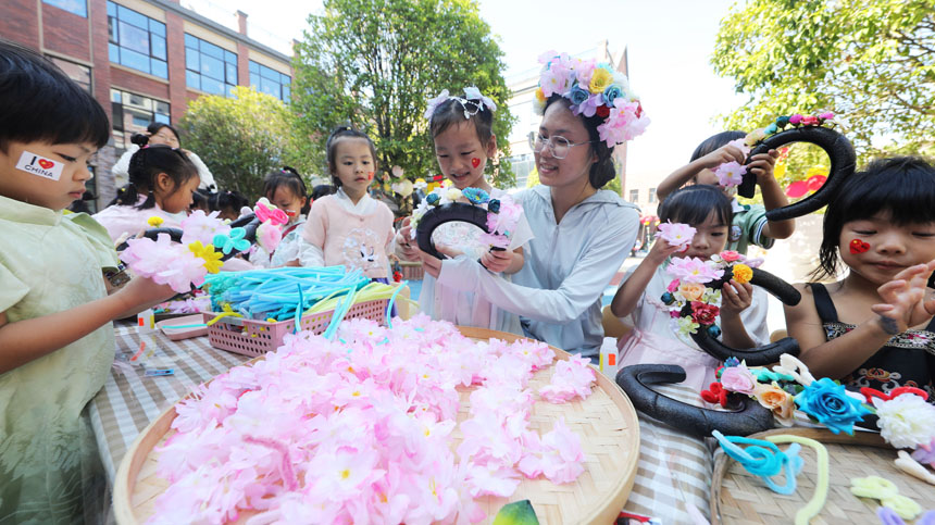 东乡区第六幼儿园，师生正在制作簪花、脸谱、苗族花带等手工作品。涂艳艳摄