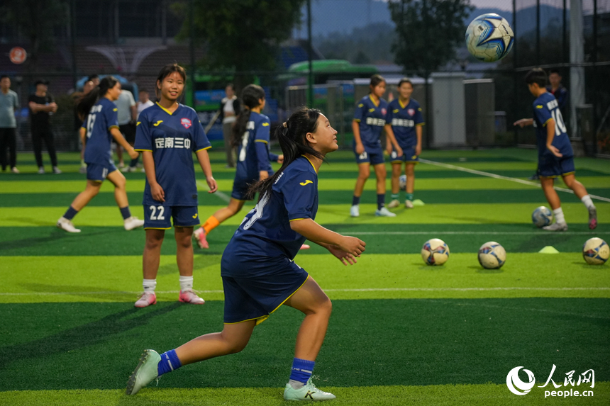 学生们利用课后时间在绿茵场上练习踢足球。人民网 涂诗轩摄