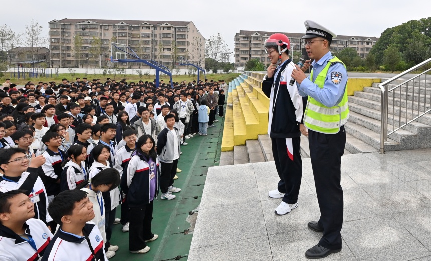 金溪县中等职业学校，当地交通警察利用国旗下讲话的时间，指导学生正确佩戴安全头盔。邓兴东摄