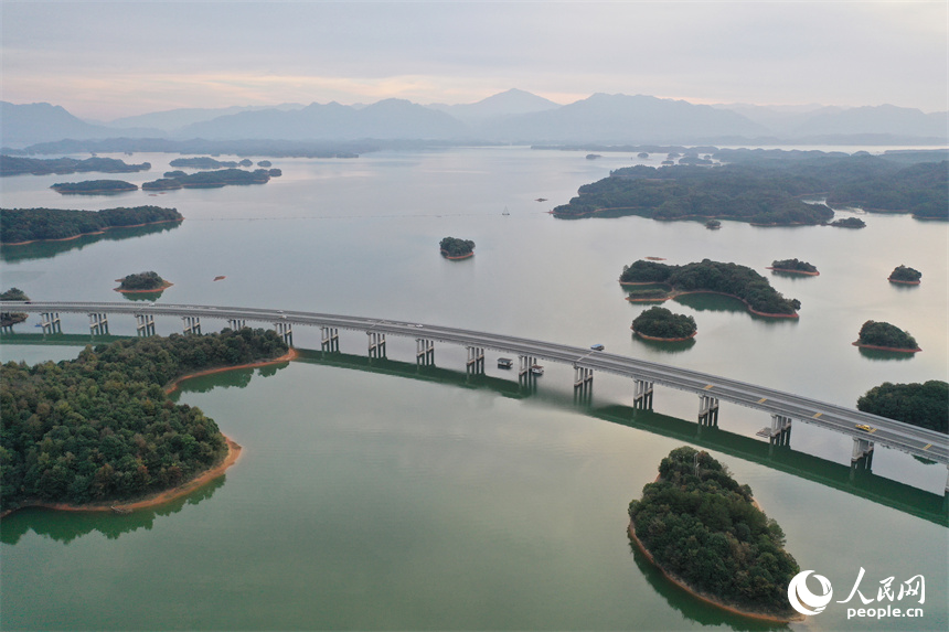 武寧縣廬山西海青山疊翠、湖面如鏡，高速公路在青山綠水間穿行。人民網記者 時雨攝