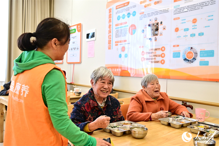 吉安市廬陵新區鳳凰社區養老中心，護工在陪同老人用餐。人民網 朱海鵬攝