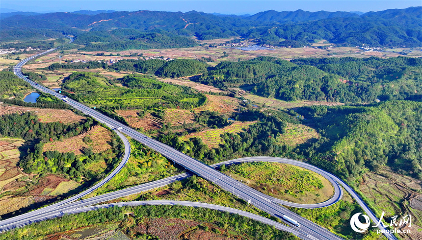 撫州市廣昌縣頭陂鎮塘下村青山掩映、阡陌縱橫，廣吉高速公路上車輛往來行駛。人民網 朱海鵬攝