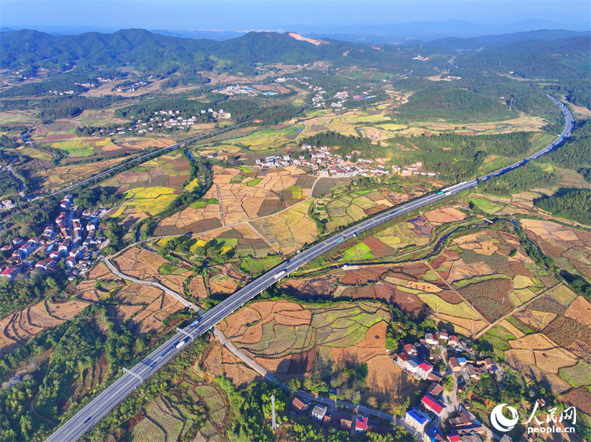 撫州市廣昌縣頭陂鎮塘下村青山掩映、阡陌縱橫，廣吉高速公路上車輛往來行駛。人民網 朱海鵬攝