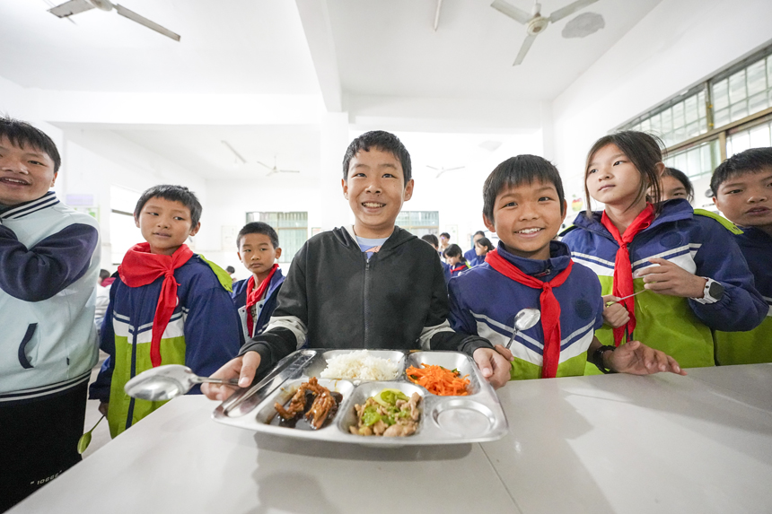 南丰县紫霄镇中心小学的学生正在享用免费营养午餐。谢东摄