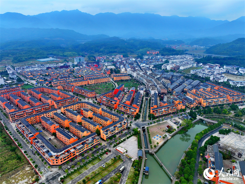 赣州市宁都县小布镇，乡村公路旁的农家房屋整齐排列，与蜿蜒河流、连绵山峦相映成景。人民网 朱海鹏摄