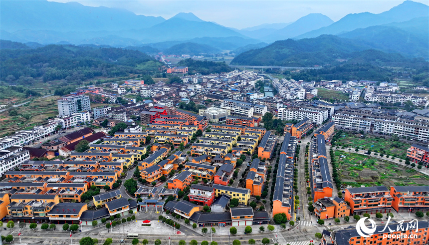 赣州市宁都县小布镇，乡村公路旁的农家房屋整齐排列，与蜿蜒河流、连绵山峦相映成景。人民网 朱海鹏摄