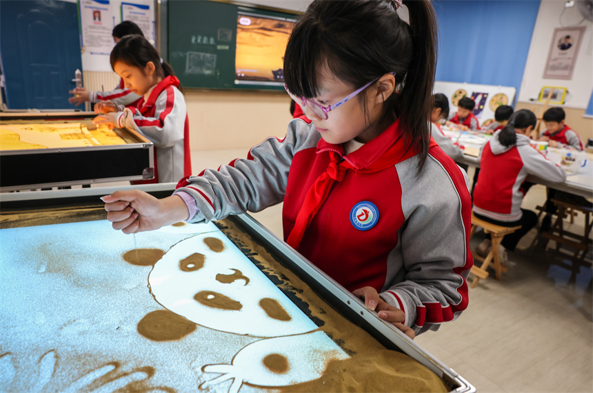 學生正在創作沙畫。李桂東攝