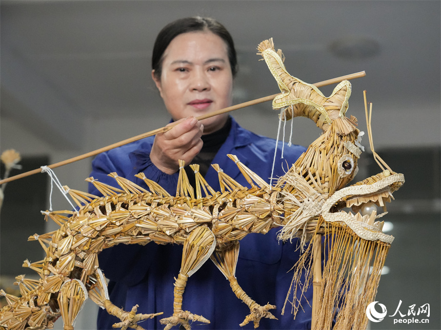 国家级非遗项目湖口草龙（草编）代表性传承人喻芳泽编织的“袖珍草龙”。人民网 孔文进摄