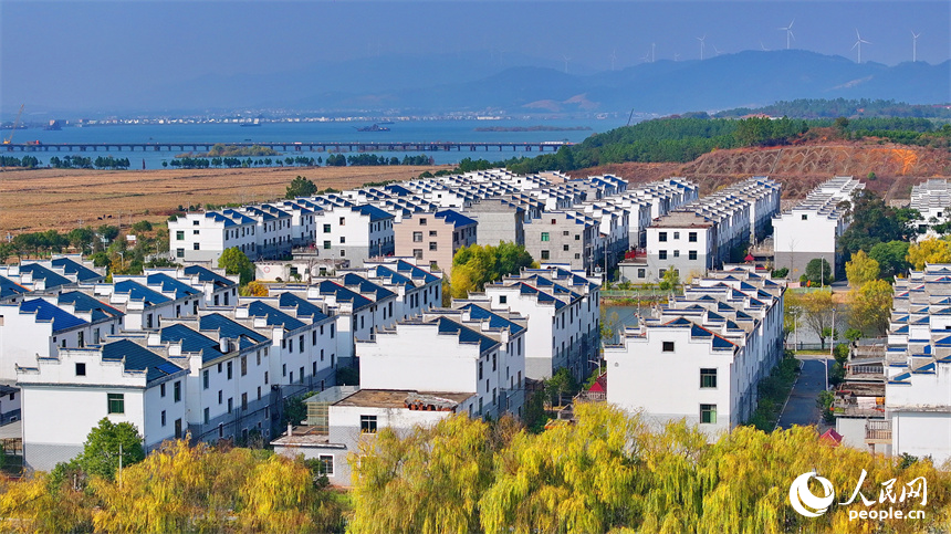 吉安市吉水縣水田鄉孔巷村移民新村，一棟棟白牆藍瓦的房屋與樹木、青山、河流相互映襯。人民網 朱海鵬攝