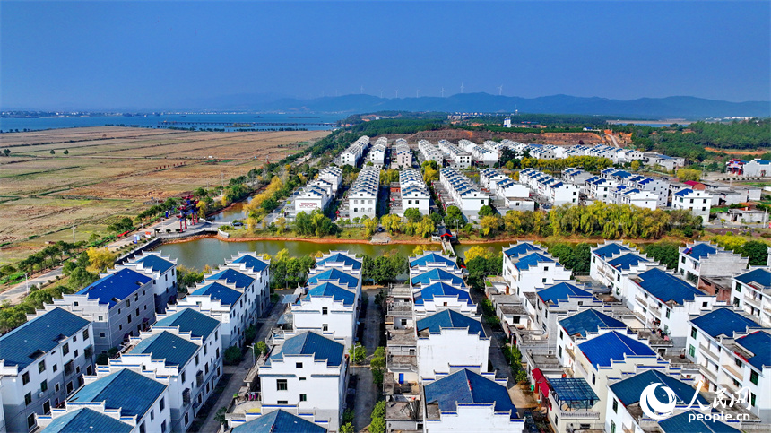 吉安市吉水縣水田鄉孔巷村移民新村，一棟棟白牆藍瓦的房屋與樹木、青山、河流相互映襯。人民網 朱海鵬攝