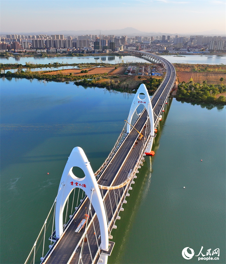 豐城市贛江水域，新建成的紫雲大橋與碧水、綠樹、建筑相映成景。人民網 朱海鵬攝