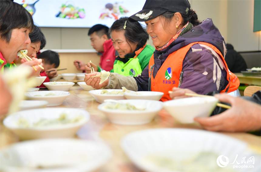 环卫工人和快递小哥开心地吃饺子。人民网记者 时雨摄