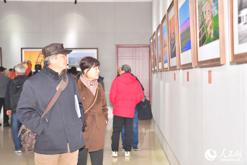 攝影愛好者們在影展上觀看展出的圖片。人民網記者 時雨攝