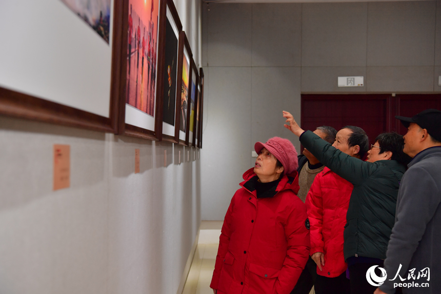 攝影愛好者們在影展上觀看展出的圖片。人民網記者 時雨攝