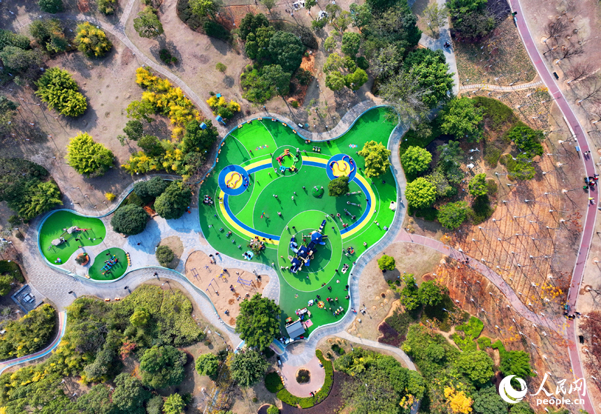 贛州市一處公園裡的兒童樂園，許多家長陪伴孩子在公園裡玩耍，暢享冬日暖陽，體驗新添置的玩樂設施。人民網 朱海鵬攝