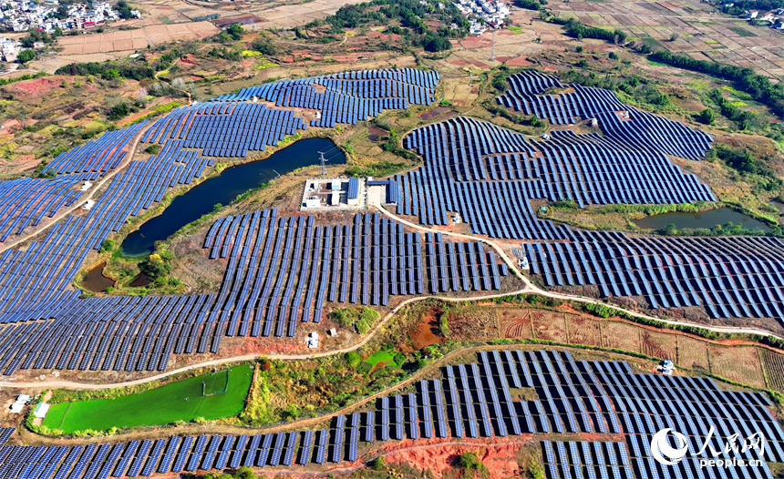 贛州市信豐縣正平鎮的一處農光互補光伏發電基地，太陽能光伏板與青山綠樹、村庄田園相映襯。人民網 朱海鵬攝