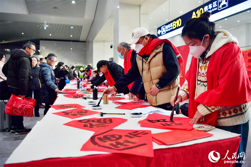 书法家在南昌火车站候车大厅内为乘客写“福”字和春联。人民网记者 时雨摄