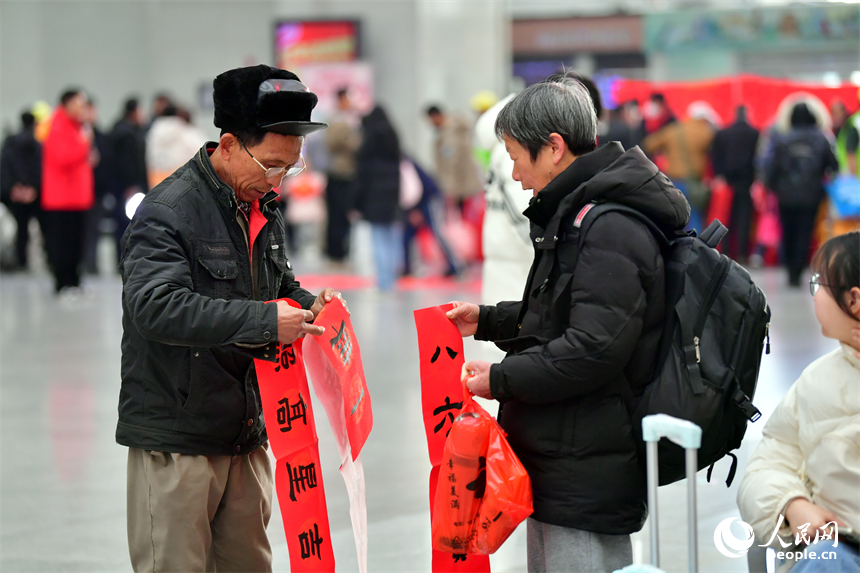 乘客整理刚刚领取到的春联。人民网记者 时雨摄