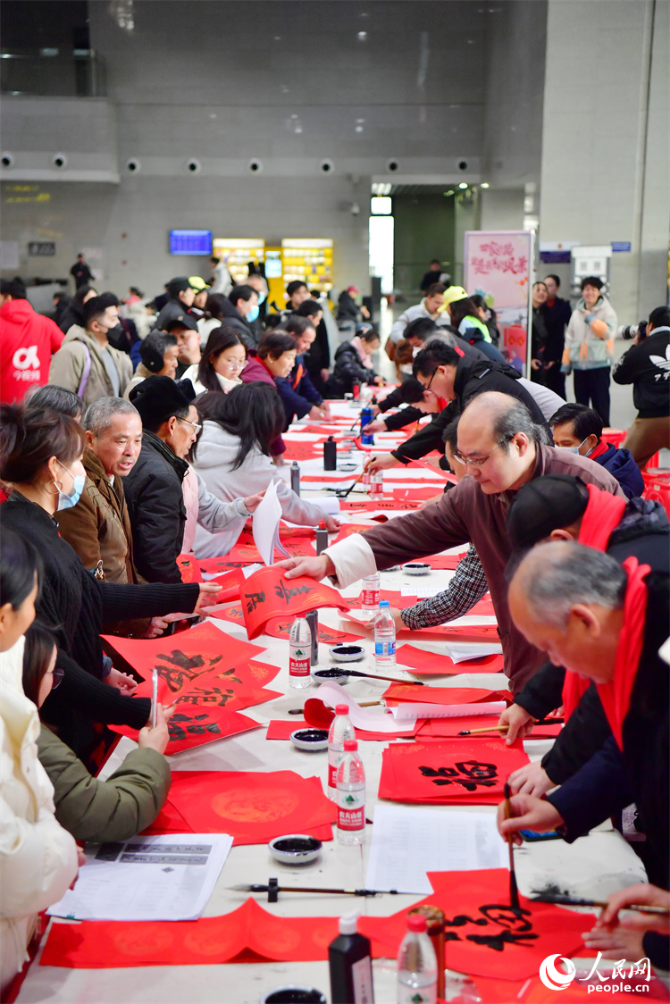 书法家在南昌火车站候车大厅内为乘客写“福”字和春联。人民网记者 时雨摄