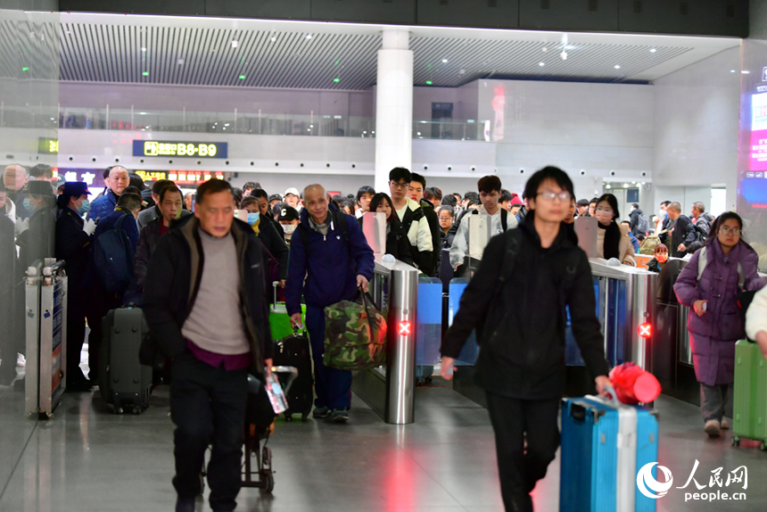 春运首日，旅客通过检票闸机准备进入站台。人民网记者 时雨摄