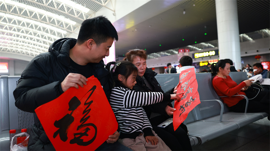 南昌火車站候車大廳內，旅客將“福”字和對聯帶回家。人民網記者 時雨攝