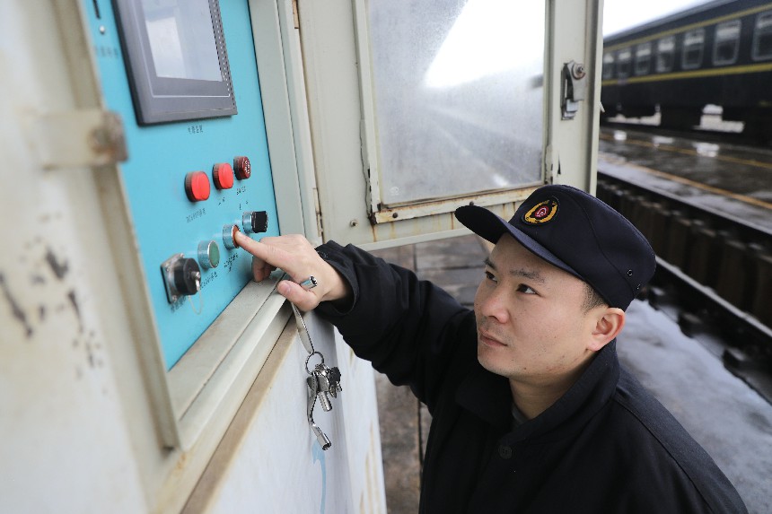 客車檢車員在對旅客列車進行供斷電作業。吳迪攝