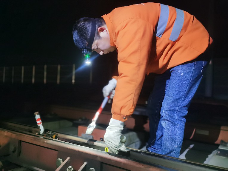 工作人員對道岔活動部位涂油，確保道岔運轉正常。劉觀仁攝