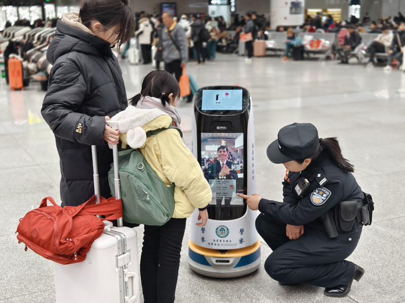 车站派出所民警利用机器人为旅客宣讲出行安全常识。人民网记者 时雨摄