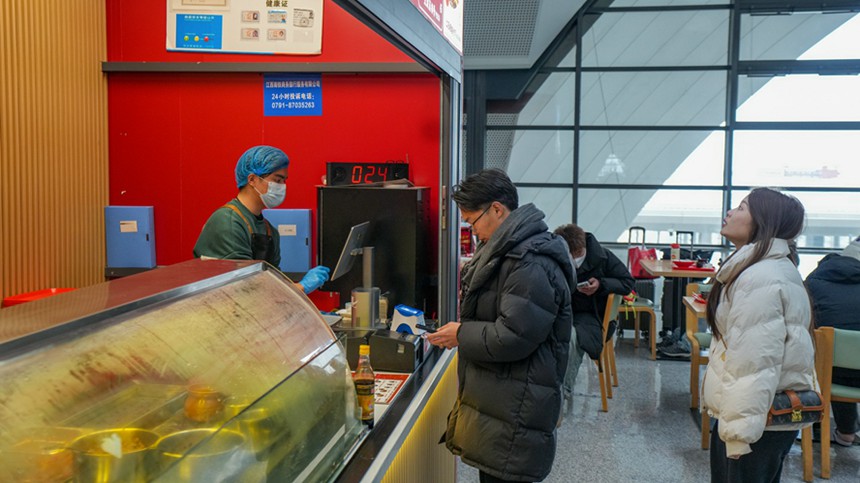 图为旅客在南昌东站粉店点餐。张超摄