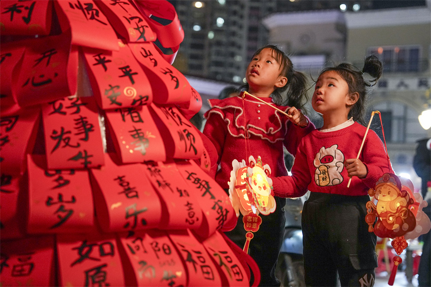 市民在南丰县国安夜市的元宵游园会上游玩。谢东摄