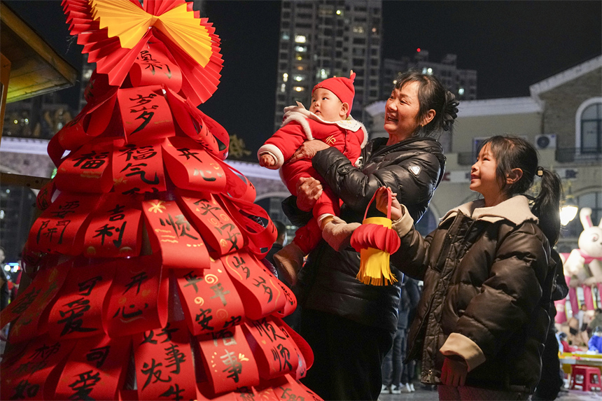 市民在南丰县国安夜市的元宵游园会上游玩。谢东摄