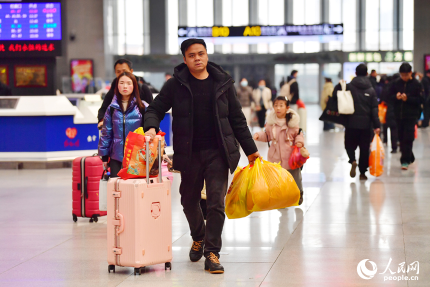 火车站内带着行李赶车的旅客。人民网记者 时雨摄