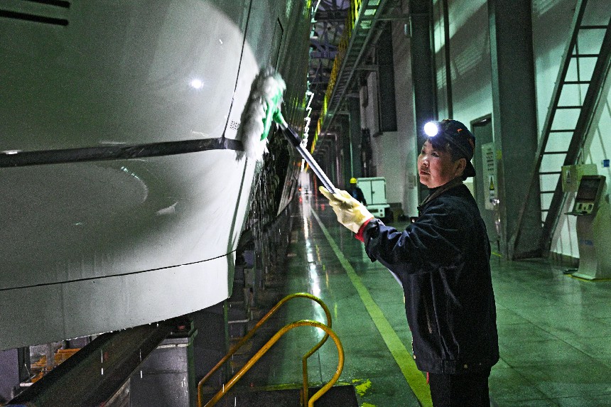 吴琼正在清洗动车组车侧。董毅摄