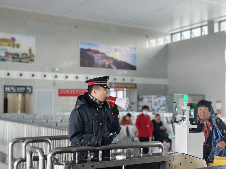 古田会址站客运员在检票口引导旅客检票进站。吕建青摄