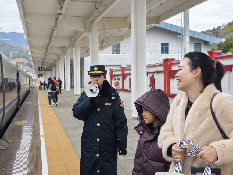 古田会址站客运值班员站台引导旅客乘降。吕建青摄