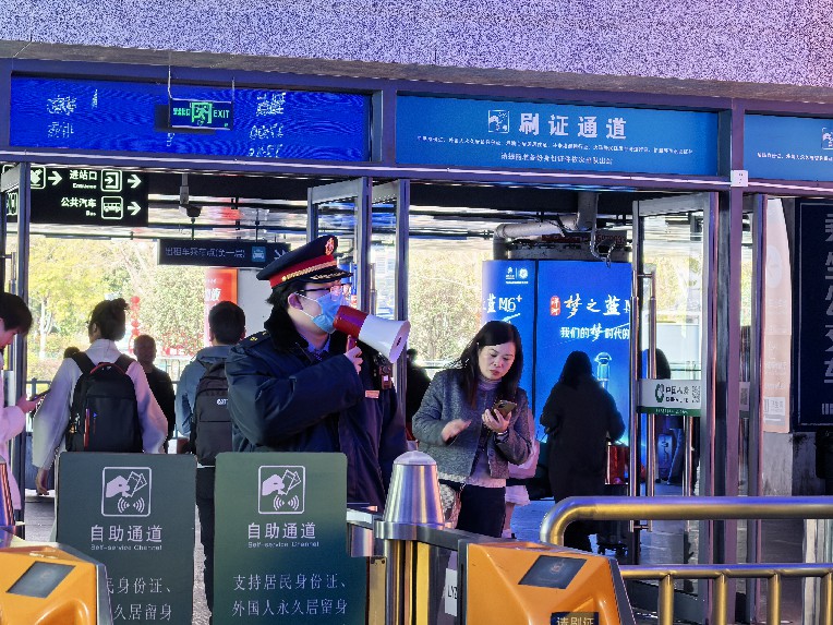 龙岩站客运员在出站口提醒旅客有序排队出站 陈玉芸摄