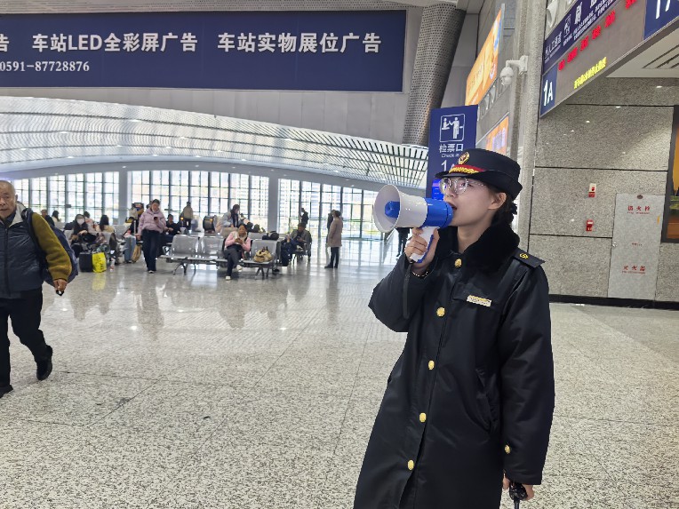 龙岩站客运员在候车室引导旅客排队检票  陈玉芸摄