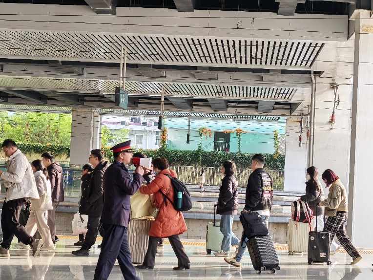 龙岩站客运员在站台提醒旅客行走在安全白线内 陈玉芸摄