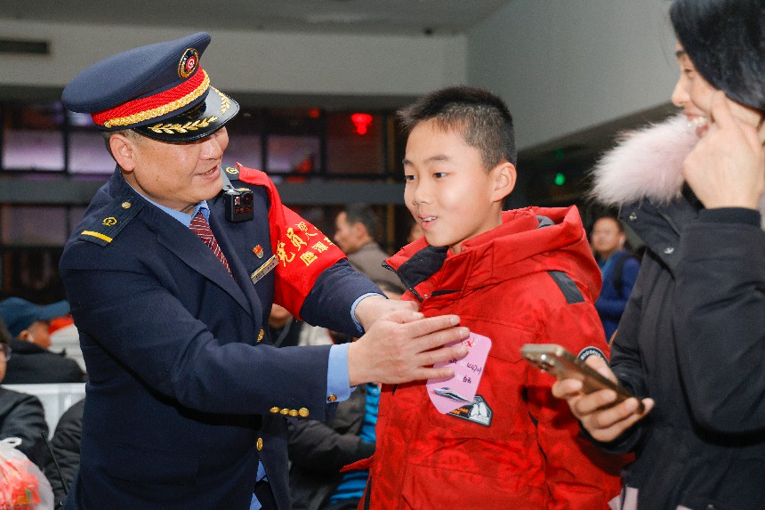 孔遠繁為兒童旅客貼“雲清”便利貼，方便兒童旅客提前進站乘車。蔡紫妍攝