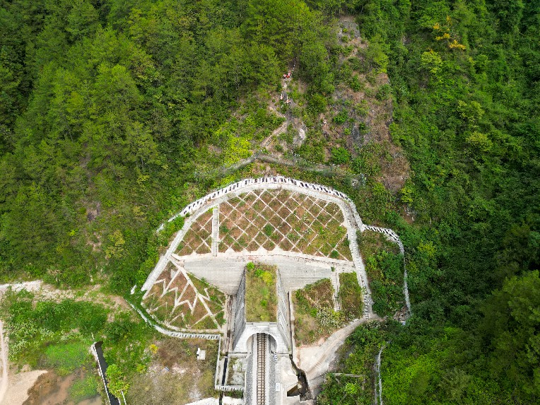 興泉鐵路黃家塢隧道上方，身著橙衣的鐵路職工正像“爬山虎”一樣攀爬在峭壁之上。李舜攝