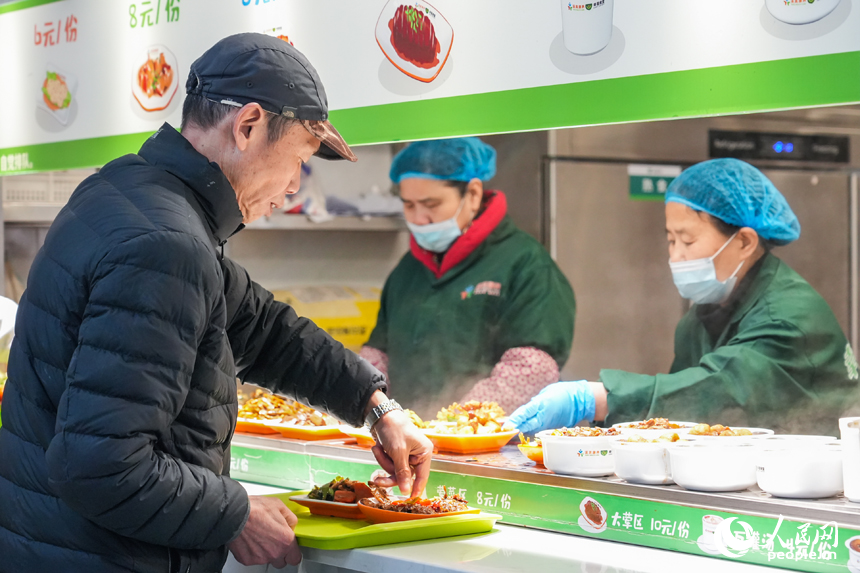 江西省南昌市東湖區光明社區幸福食堂，老年人正在選購菜品。人民網 孔文進攝