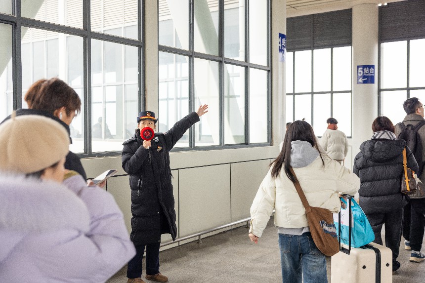 鹰潭北站工作人员在天桥引导旅客。张坤茹摄