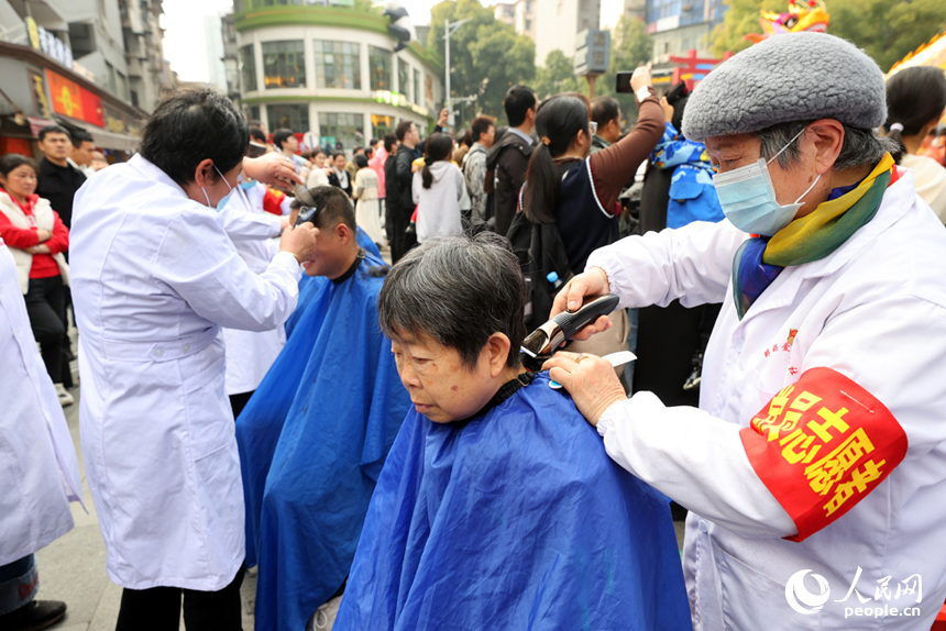 志愿者们现场为民众“剃龙头”。人民网记者 时雨摄